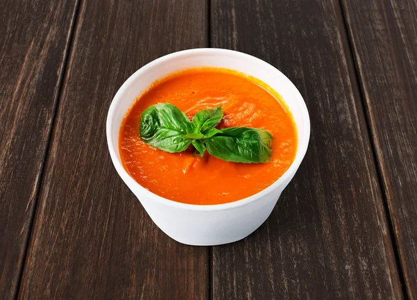 Lieferung von warmem Essen - Tomaten-Gazpacho-Suppe an braunem Holz — Stockfoto