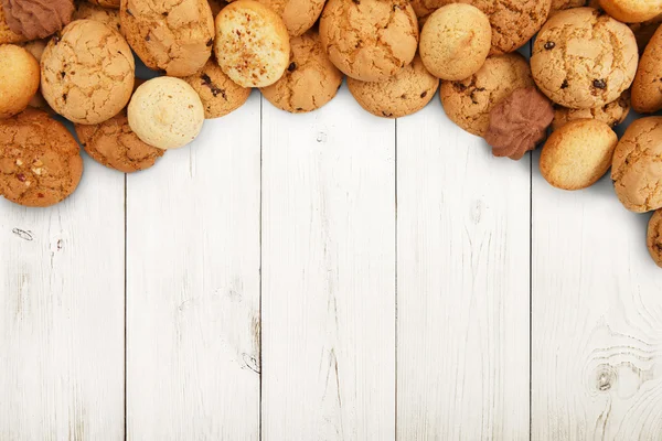 Biscoitos e biscoitos em madeira branca com espaço de cópia — Fotografia de Stock