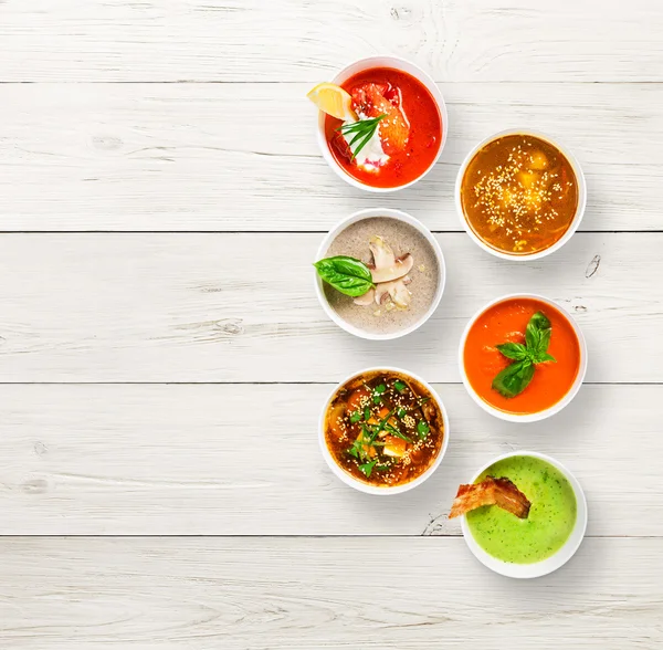 Variety of soups at white wood, top view, copy space — Stock Photo, Image