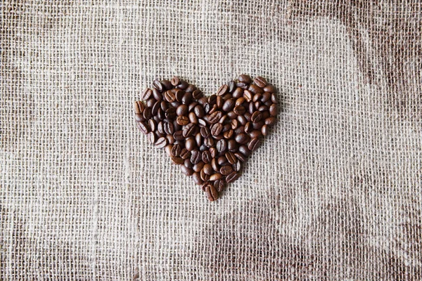 Texture di iuta con chicchi di caffè a forma di cuore — Foto Stock