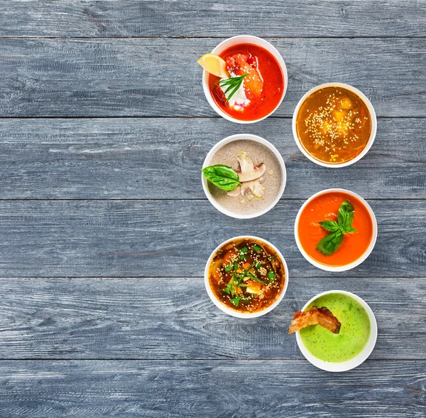 Sechs Suppen auf blauem Holz, Draufsicht mit Kopierraum — Stockfoto