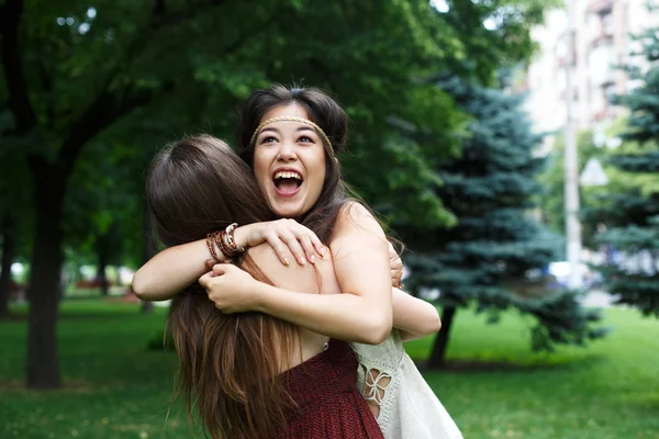 Deux jeunes filles heureuses s'embrassent dans un parc d'été — Photo