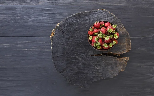素朴な木製の黒地に赤の新鮮なイチゴ — ストック写真