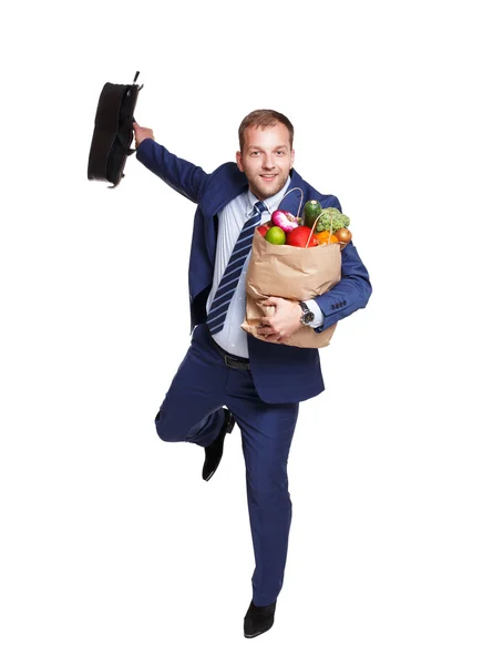 Hombre feliz correr con bolsa de comida saludable, comprador de comestibles aislado — Foto de Stock