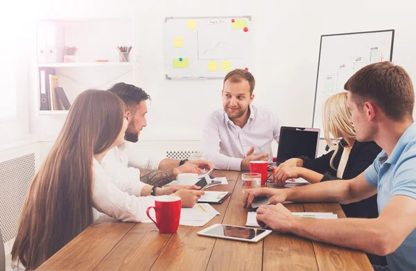 Réunion d'affaires. Jeunes hipsters hommes et femmes d'affaires au bureau moderne — Photo