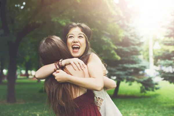 Two happy young girls hug each other in summer park — Stock Photo, Image