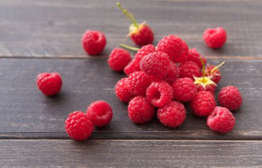 Kahverengi rustik ahşap arka plan üzerinde kırmızı taze frambuaz