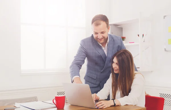 El hombre de negocios que supervisa a sus asistentes femeninos trabaja en la computadora portátil — Foto de Stock