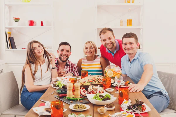 Group of happy young people at dinner table, friends party — Stock Photo, Image