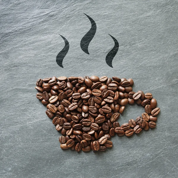 Copo de grãos de café no fundo de pedra — Fotografia de Stock