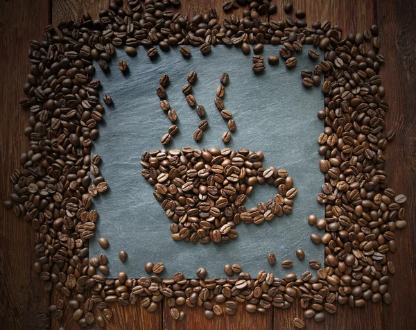 Cup från kaffebönor på sten bakgrund — Stockfoto