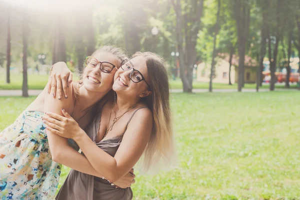 Két boldog fiatal lányok ölelés egymással nyár park — Stock Fotó