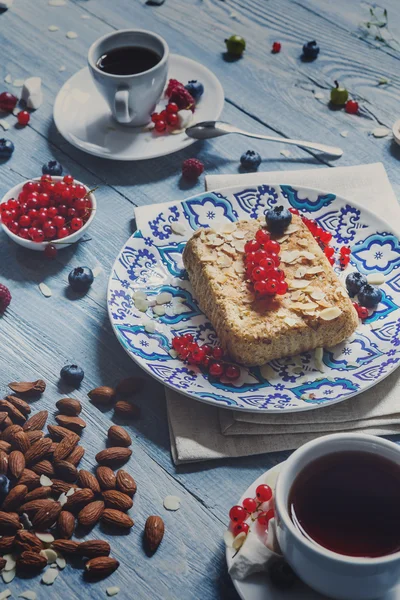 Gebak-pie, thee, koffie en bessen op blauwe rustiek hout — Stockfoto