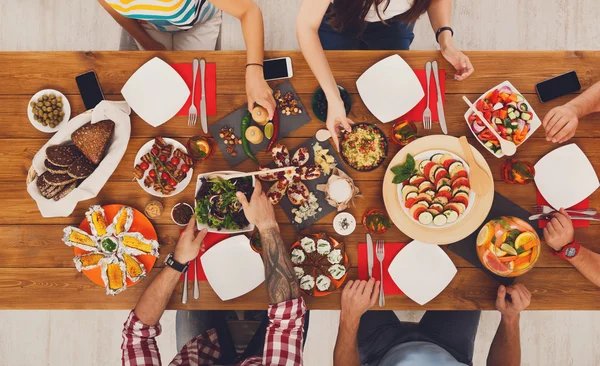 Mensen eten gezonde maaltijden op feestelijke tabel diner — Stockfoto