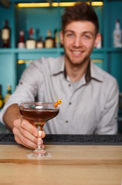 Genç barmen gece kulübü barda kokteylin alkol sunar