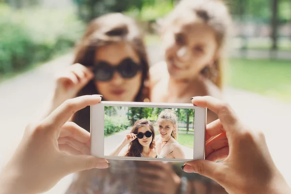 Chicas amigas tomando fotos con smartphone al aire libre — Foto de Stock