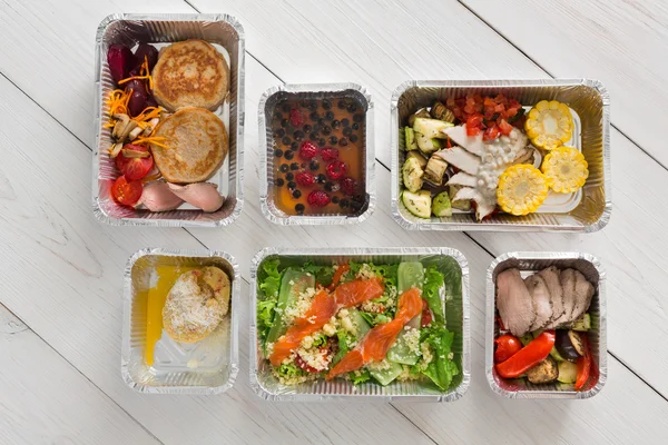 Alimentos saudáveis levam em caixas, vista superior em madeira — Fotografia de Stock