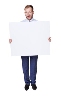 Winking businessman show blank advertising board, isolated on white