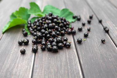 Siyah kuş üzümü yığın closeup rustik ahşap zemin üzerine