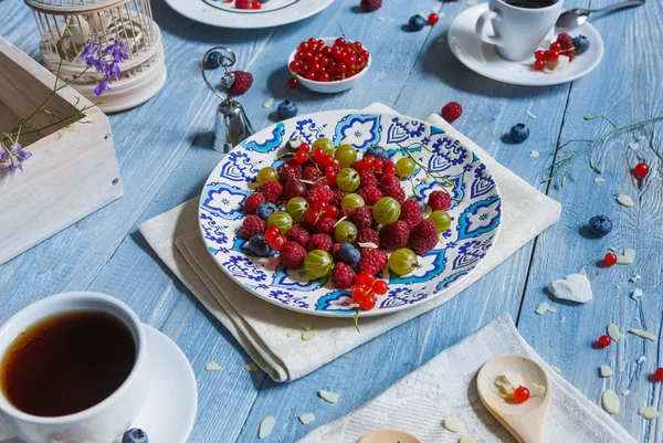 Ontbijt met gebakken erwt en bessen op blauwe rustiek hout — Stockfoto