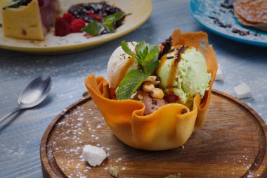 Restoran tatlısı. Waffle kasesinde dondurma kepçeleri