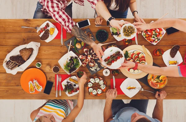 Mensen eten gezonde maaltijden op feestelijke tabel diner — Stockfoto