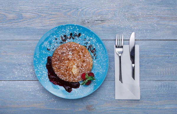 Restaurant dessert. Pancakes with raspberry sauce on blue wood — Stock Photo, Image