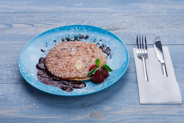 Restaurant dessert. Pancakes with raspberry sauce on blue wood — Stock Photo, Image