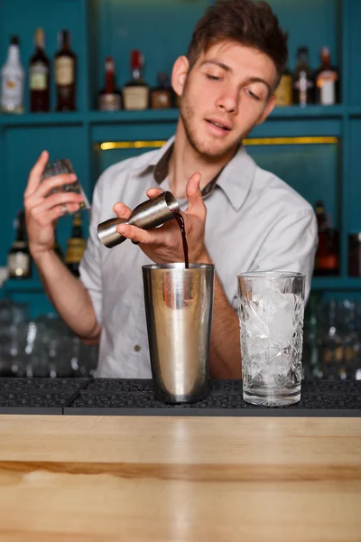 Jonge knappe barman cocktail drinken in glas gieten — Stockfoto