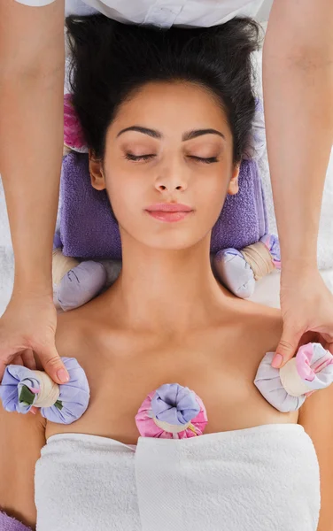Kobieta ma ziołowe piłka do masażu w centrum odnowy biologicznej spa ayurveda — Zdjęcie stockowe