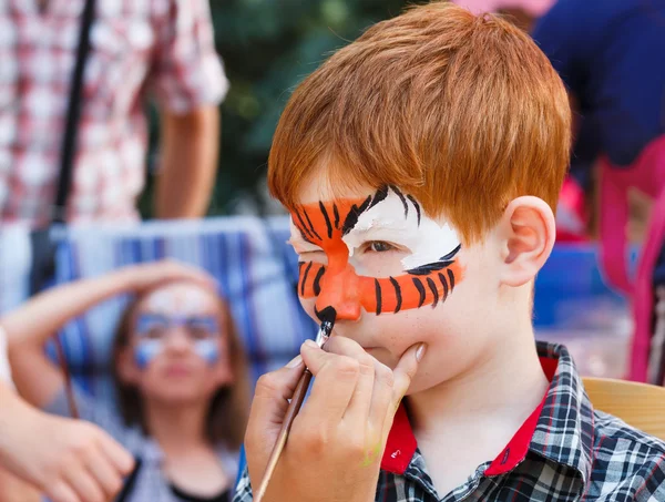 Dziecko chłopiec twarz malarstwo, oczy proces podejmowania Tygrys — Zdjęcie stockowe