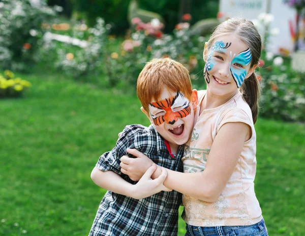 Glada barn, pojke och flicka med ansiktsmålning i park — Stockfoto