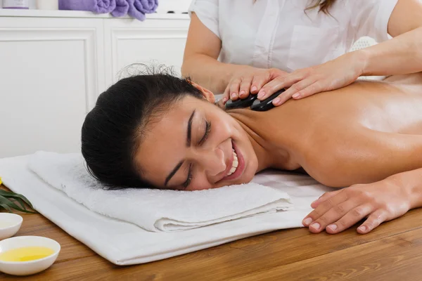 Kosmetyczka make kamieniu masaż spa dla kobiety w centrum odnowy biologicznej — Zdjęcie stockowe