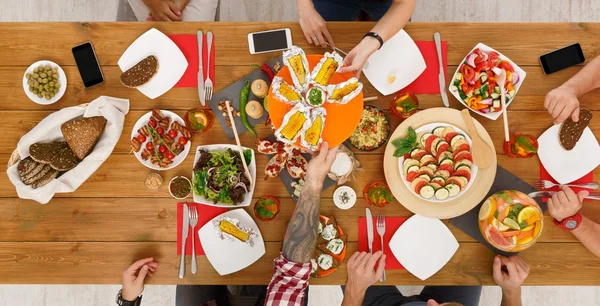 As pessoas comem milho grelhado no jantar de mesa servido — Fotografia de Stock