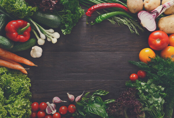 Frame of fresh vegetables on wooden background with copy space