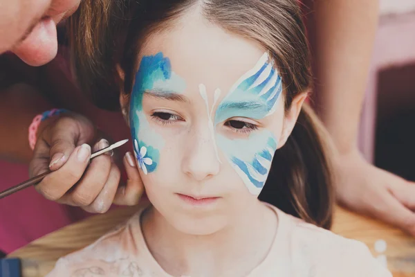 Pintura de cara de niño femenino, proceso de mariposa — Foto de Stock