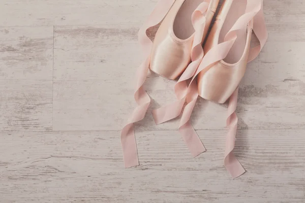 Zapatillas puntas de ballet rosa sobre fondo de madera blanca —  Fotos de Stock