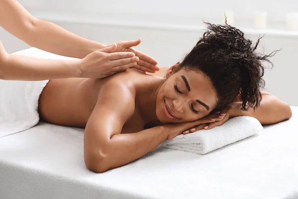 Svart kvinna som har kropp massage session på modernt spa — Stockfoto