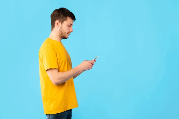 Porträt eines jungen Mannes, der sein Handy benutzt — Stockfoto