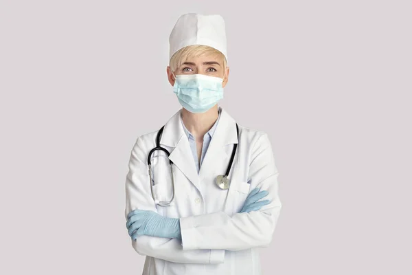 Dospělá žena lékař v bílém plášti se dívá do kamery — Stock fotografie