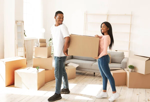 Inquilinos afroamericanos llevando caja de cartón con pertenencias en nuevo hogar — Foto de Stock