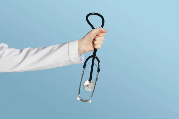 Die Hand einer Ärztin in weißer Uniform hält ein Stethoskop für die Behandlung der Patientin während Covid-19 — Stockfoto