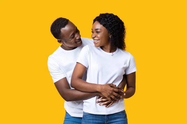 Gelukkig jong Afrikaans amerikaans man knuffelen zijn glimlachende vriendin — Stockfoto