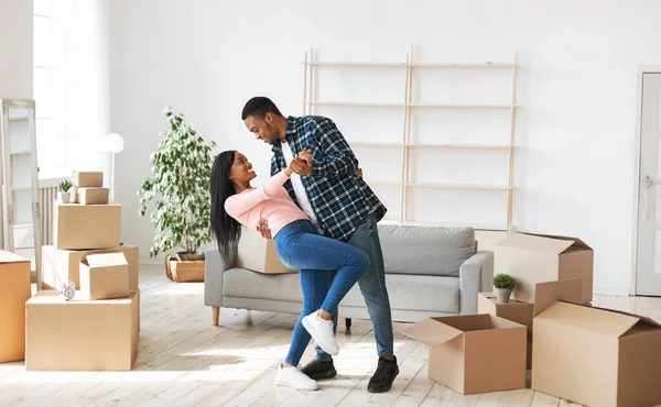 Amante casal negro dançando em sua casa entre caixas de papelão no dia em movimento — Fotografia de Stock