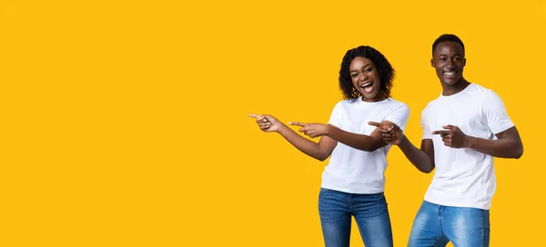 Emotional black man and woman pointing at empty space — Stock Photo, Image