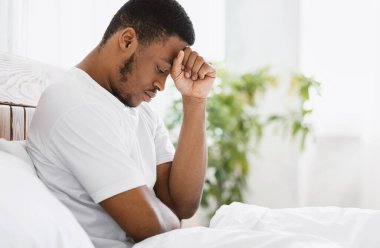 Afro-Amerikalı Adam Evde Yatakta Otururken Depresyon geçiriyor