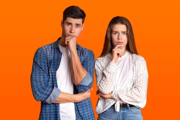 Reflecteer en moeilijke keuzes. Pensive paar, jonge man en vrouw druk handen aan kin en kijkt naar de camera — Stockfoto