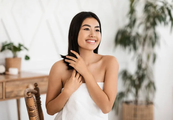 Atraente sorrindo mulher asiática aplicando tratamento de cabelo em casa — Fotografia de Stock