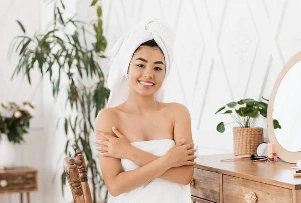 Joyful asiática dama en toalla tocando su piel — Foto de Stock