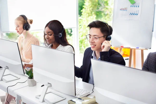 Equipe de operadores de linha de ajuda com fones de ouvido clientes de consultoria no call center — Fotografia de Stock